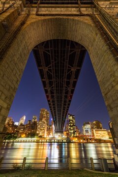 UNITED STATES, NEW YORK CITY, MANHATTAN, ROOSEVELT ISLAND. NIGHT VIEW OF MIDTOWN EAST SKYSCRAPERS FROM BELOW THE ED KOCH QUEENSBORO BRIDGE
