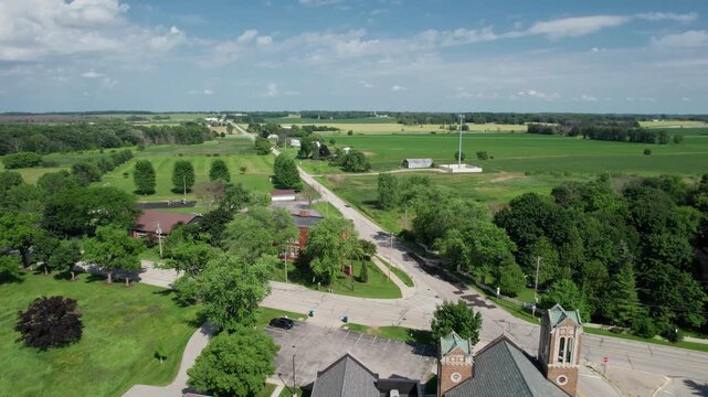Right to Left Aerial of church off of Lake Michigan in Wisconsin.  Countryside and green fields, along long tree covered roads.