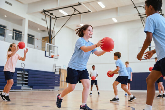 Children playing dodgeball in a school gymnasium
