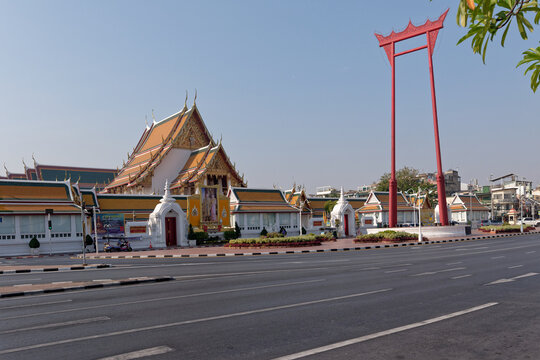 Famous Giant Swing red teak structure and Wat Suthat temple against clear blue sky in Bangkok, Thailand.