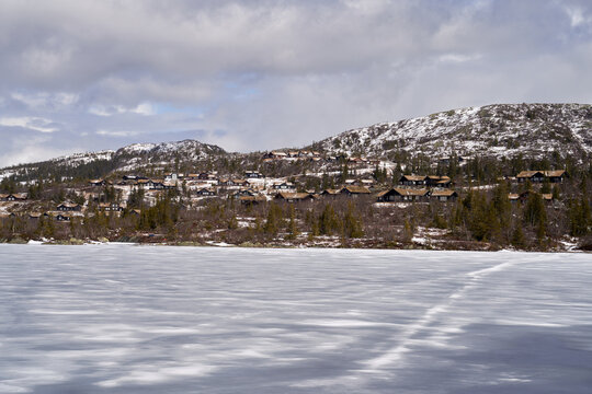 Norefjell Winter Scene: Frozen Lake and Rustic Mountain Cabins
