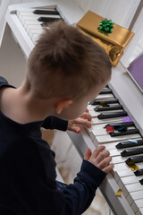 Child playing piano with colorful confetti on keys during festive celebration © Nataliia
