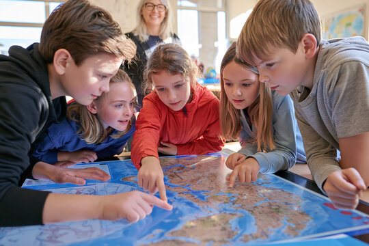 Children and teacher looking at a digital map in a classroom