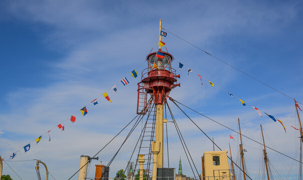 Historic ship light tower decorated with maritime signal flags.