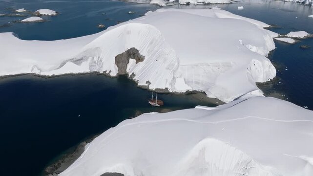 Sailing Ship Beside Sunken Whaling Vessel in Antarctica