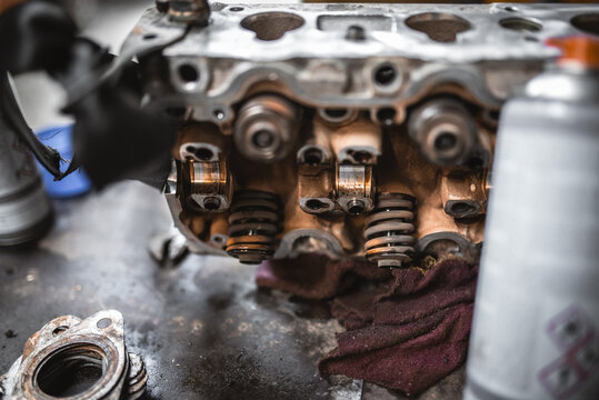 Close-up of a car engine cylinder head with visible valves and springs