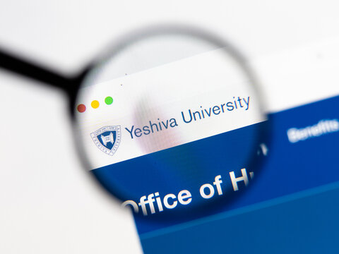 Milan, Italy 2026, 15 AGO Closeup of Yeshiva University website page on a laptop screen. Focus on Yeshiva University logo under a magnifying glass.