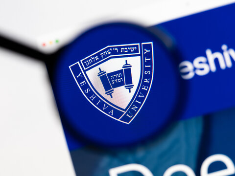 Milan, Italy 2026, 15 AGO Closeup of Yeshiva University website page on a laptop screen. Focus on Yeshiva University logo under a magnifying glass.
