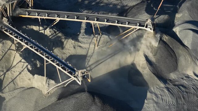 Coal being processed and moved by a conveyor belt at an open pit mining operation in Indonesia