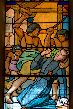 A stained glass window depicts the martyrdom of Saint Peter Chanel.