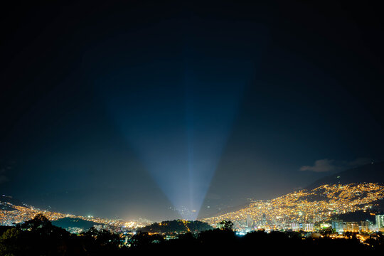 Searchlight Beam Piercing the Night Sky Over Medellin