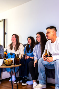 Young friends enjoying a soccer match at home, celebrating sports and friendship