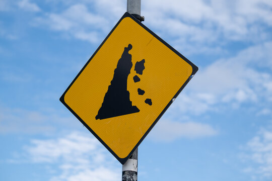 Rockfall Warning Road Sign Against Blue Sky