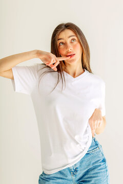 Young woman pointing at her cheek with a playful look