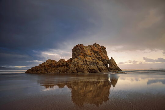Sea stacks at the easternmost end of the Bayas sandstrip and dune system, the Playa Requexinos Beach, on a glowing dawn. Castrill&oacute;n-Asturias-Spain-044