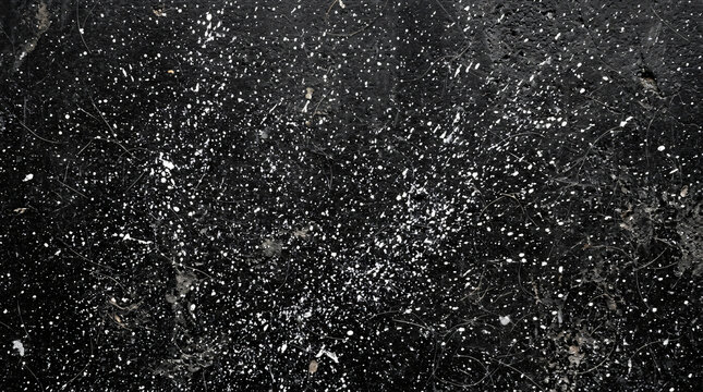 High density full frame top view texture background solid dark black concrete floor surface completely covered multiple chaotic white paint specks fine hair strands micro dust particles