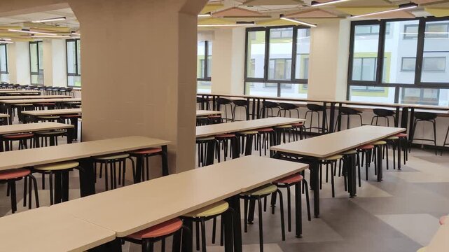 Empty modern school cafeteria interior with tables and chairs