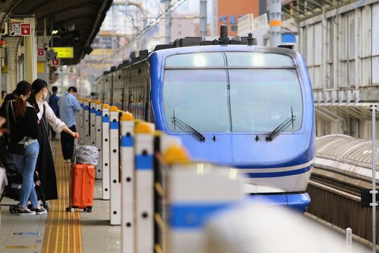 可動式ホーム柵のある駅ホームに到着する特急列車