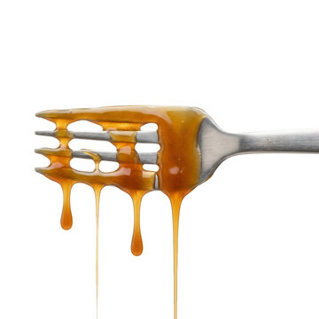 Calda de caramelo dourada e viscosa escorrendo de forma brilhante pelos dentes de um garfo de metal, isolado contra um fundo branco limpo.