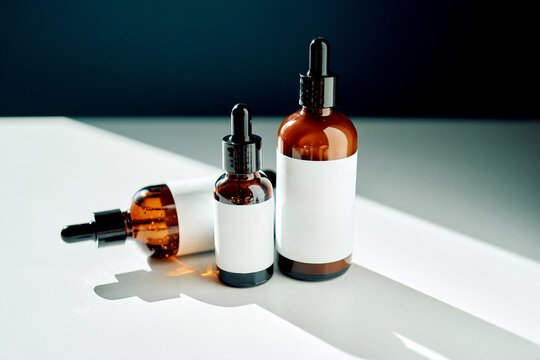 Cosmetic serum bottles with blank labels in sunlight