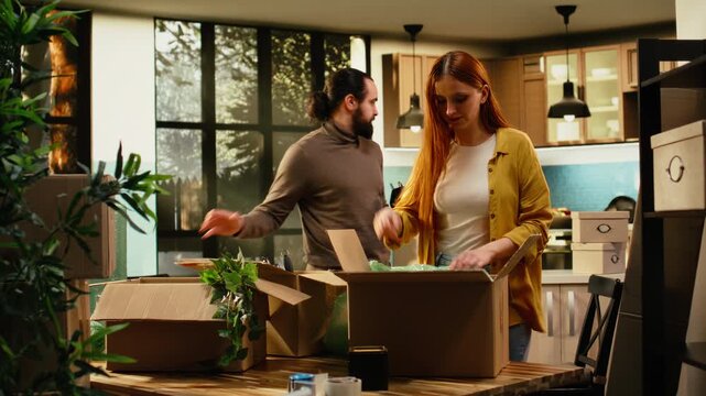 Partners unpacking wrapped furniture together to settle in first home