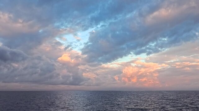 Cinematic ocean background footage featuring vibrant twilight sky, textured clouds, and peaceful water ripples