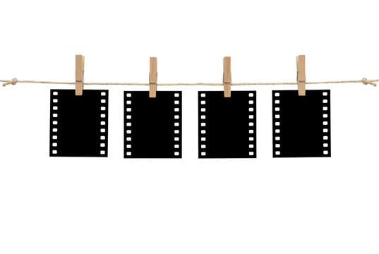 Cztery puste klatki filmu fotograficznego zawieszone na sznurku za pomocą drewnianych klamerek, odizolowane na białym tle, idealne jako miejsce na własne zdjęcia lub kreatywny projekt graficzny.