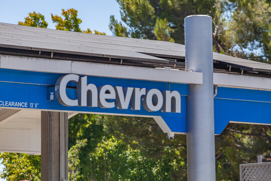 Commercial fuel‑station canopy showing Chevron branding on exterior paneling with metallic column and outdoor setting