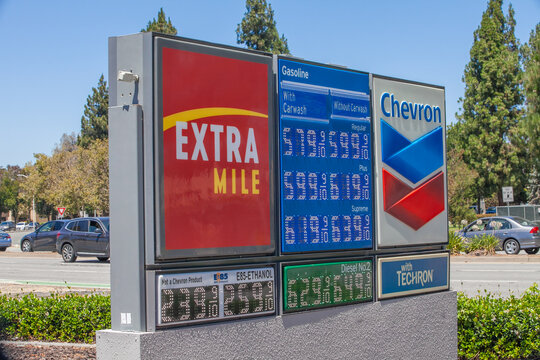 Roadside Chevron price sign listing multiple fuel grades and diesel costs beneath ExtraMile branding at a busy station