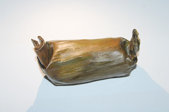 Indonesian lemper wrapped in banana leaf isolated on white background