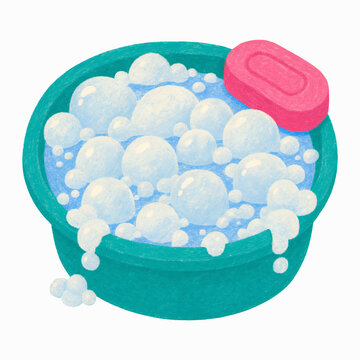 A turquoise plastic washbasin completely filled with fluffy white soap bubbles and a small pink rectangular bar of soap resting on its side rim.