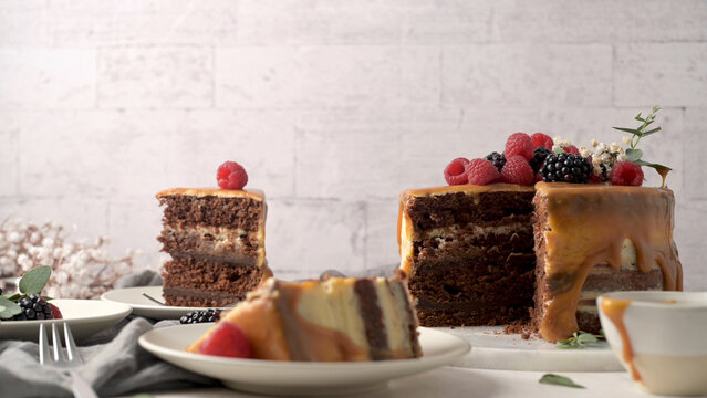 Chocolate layer cake with caramel and fresh berries on plates