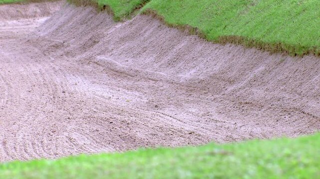 The background of the sand traps on the golf course is beautiful.