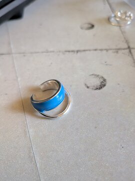 使い込まれた机の上に置かれた青いイヤーカフ