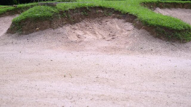 A golf course sand trap is shown clearly from a straight-on view of the sand.