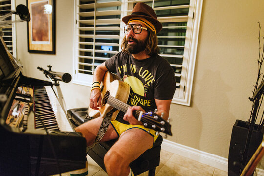Man Dressed up in Vintage Outfit Playing Guitar