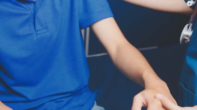 Doctor physiotherapist assisting a male patient while giving exercising treatment massaging the arm of patient in a physio room, rehabilitation physiotherapy concept
