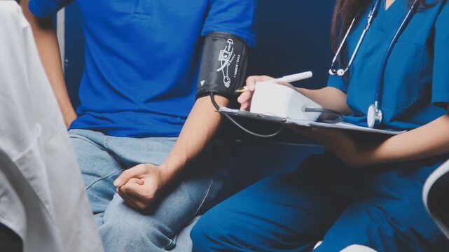 Female healthcare worker taking blood pressure on an adult male patient in a medical clinic, close-up with cropped faces