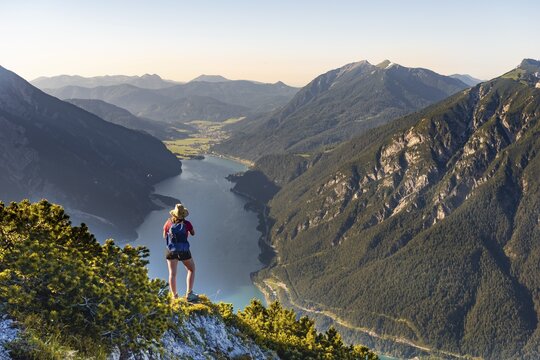 Young hiker, woman looking into the distance, view from B&auml;renkopf mountain to Lake Achen, left Seebergspitze and Seekarspitze, right Rofan Mountains, Tyrol, Austria