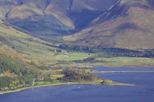 Green valley with a body of water and surrounded by high mountains under a blue sky, October, Hebrides, Isle of Skye, Hebrides, Scotland, United Kingdom