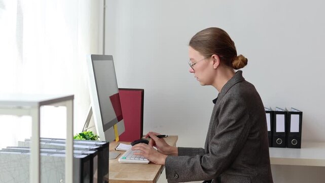 Businesswoman experiencing back and neck pain from prolonged computer use, showing poor posture, fatigue, and discomfort while sitting at her office desk and working