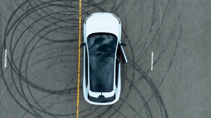 Woman stands near ev car. She poses by white ev car. Stylish ev car on road. © Nutchanart