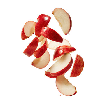 Fresh red apple slices falling in mid-air isolated on white background