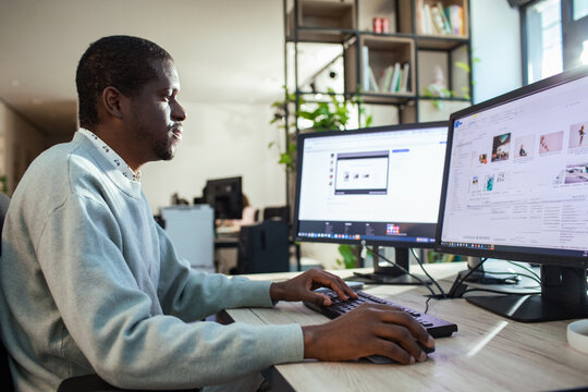 Man working at dual monitors in modern office