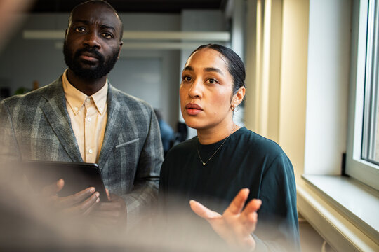 Two business colleagues discussing strategy in modern office