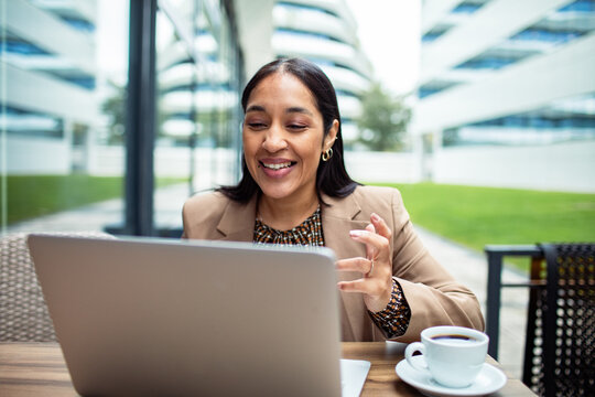 Smiling businesswoman on video call at outdoor cafe
