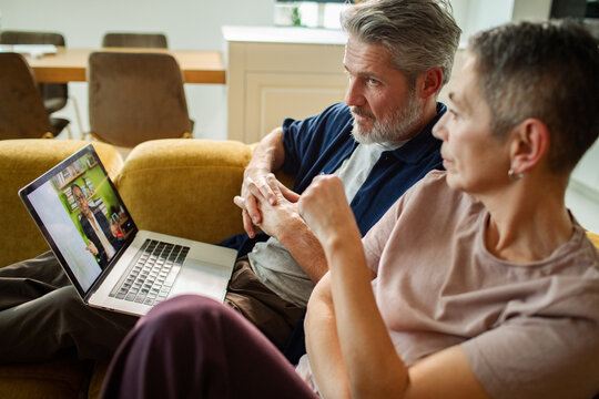 Middle-aged couple watching online webinar at home