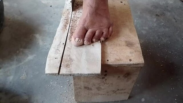 Hand sawing a wooden board with a manual hand saw. Close-up footage of a person sawing a wooden board using a traditional hand saw during a woodworking, construction, or repair activity.