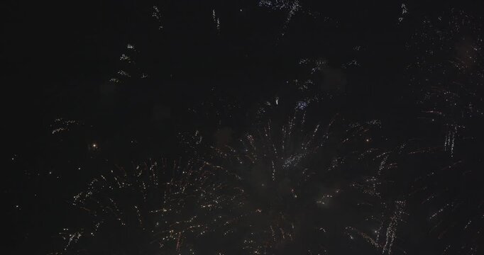 夜空で鮮やかに爆発して五色の火の粉を散らす大迫力の打ち上げ花火と飛び散る火花の美景映像