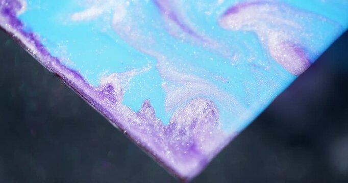 Marble paint. Shimmer mix. Defocused blue purple color sparkling triangle fluid spilling texture on abstract art background.